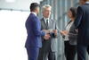 a group of business people standing and talking